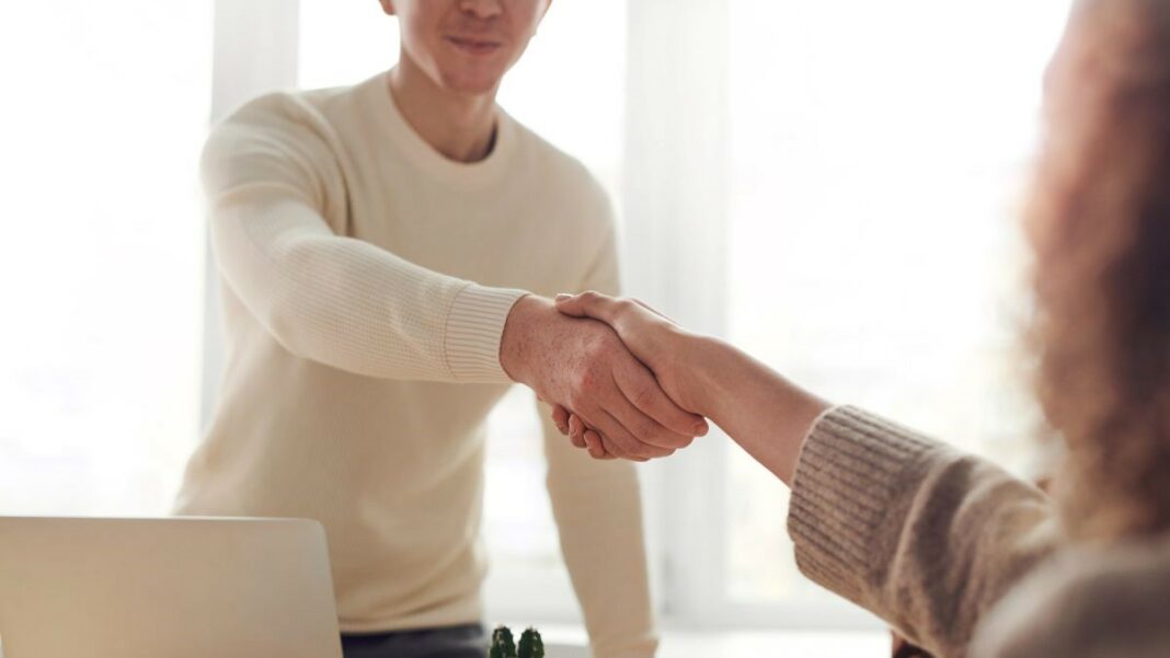 business ideas represented by a man an woman shaking hands near a table