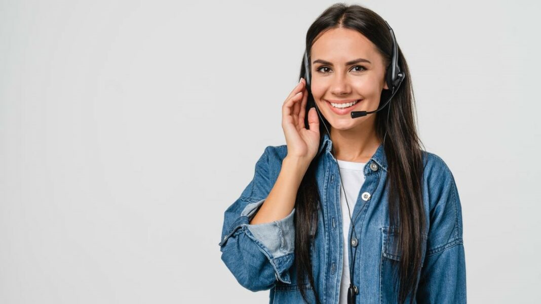 call overflow represented by a young cheerful woman wearing a blue denim shirt and a phone headset