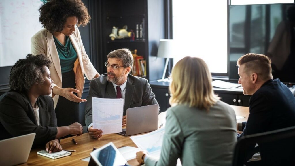 executive search represented by businesspeople having a discussion around a conference table