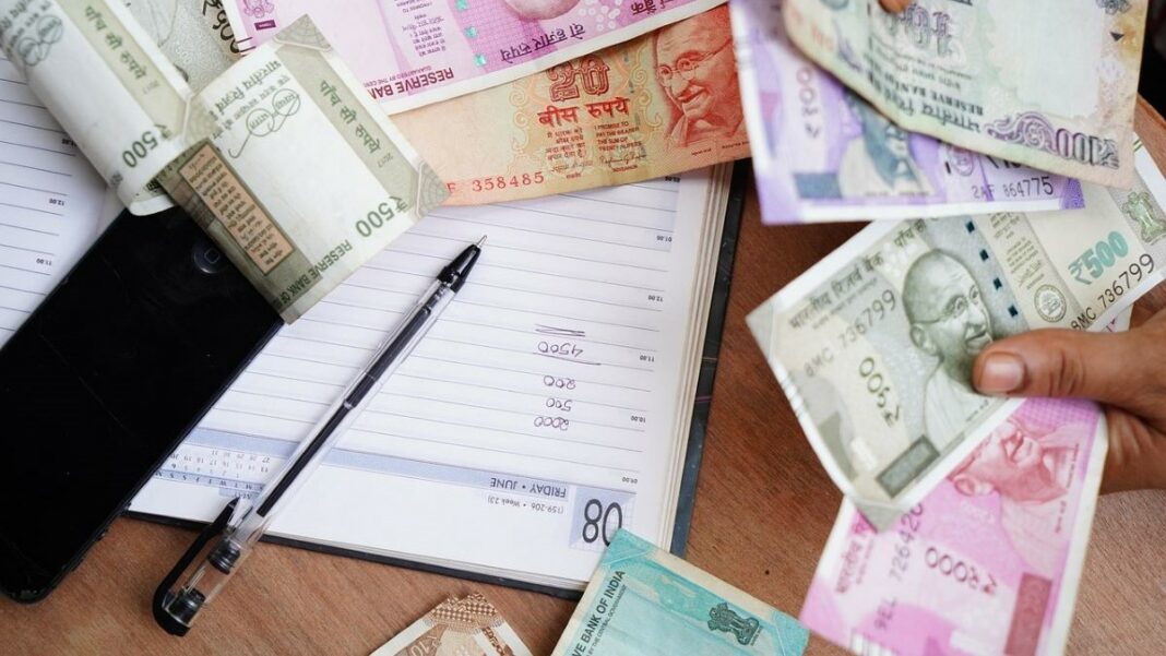 money transfer represented by a man's hands as he counts rupees