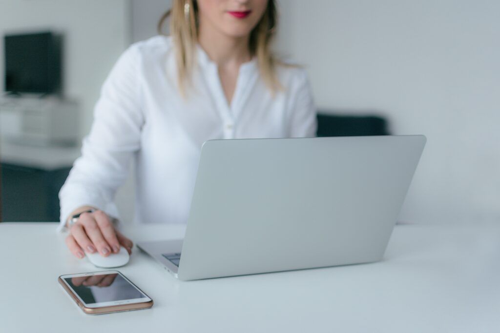 Woman with long blond hair sitting in front of laptop utilizing digital procurement for business