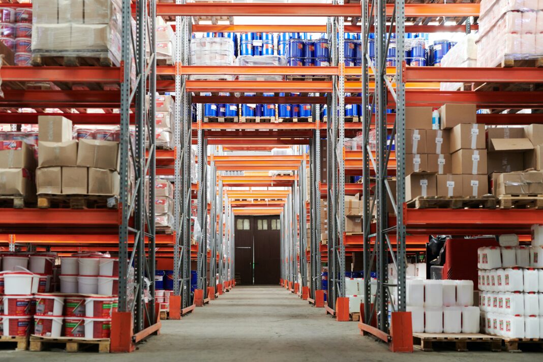 Neatly organized warehouse storage shelves with orange and silver steel shelves.