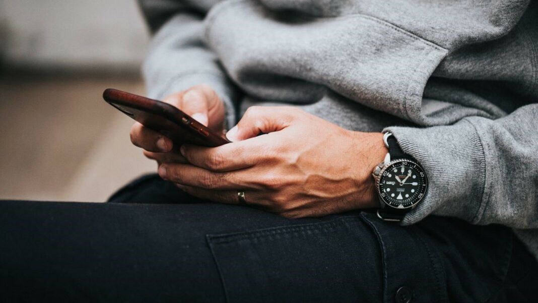 sms marketing represented by a man's hands poised over a cell phone